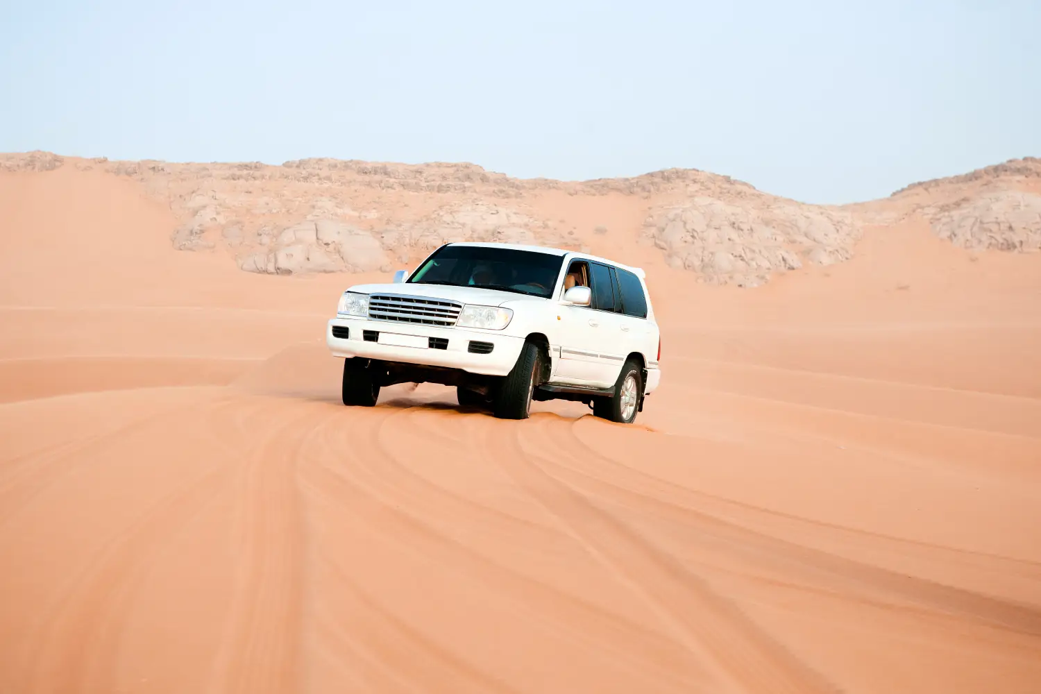 Toyota Land Cruiser and Nissan Patrol parked side by side on a Dubai road, comparing reliability, comfort, and off-road performance in the UAE.